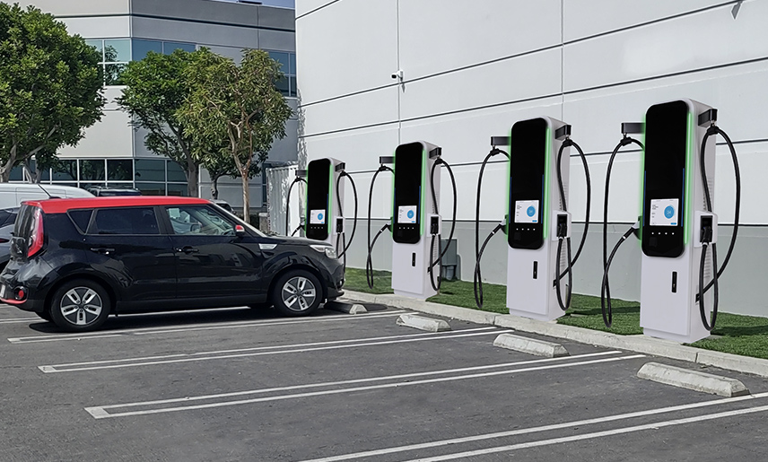 Row of commercial DC fast EV charging stations in a business parking lot